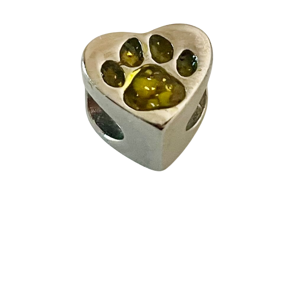 Heart-shaped silver charm with embedded green stones on a white background